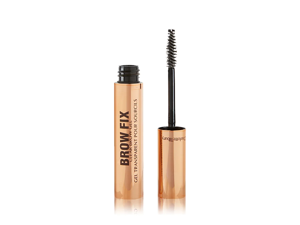 Clear brow gel in a gold-coloured tube with its applicator next to it.