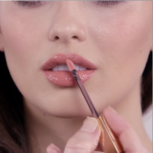 Model applying Lip Lustre in Sweet Stiletto to give the lips a glossy, soft-pink shine