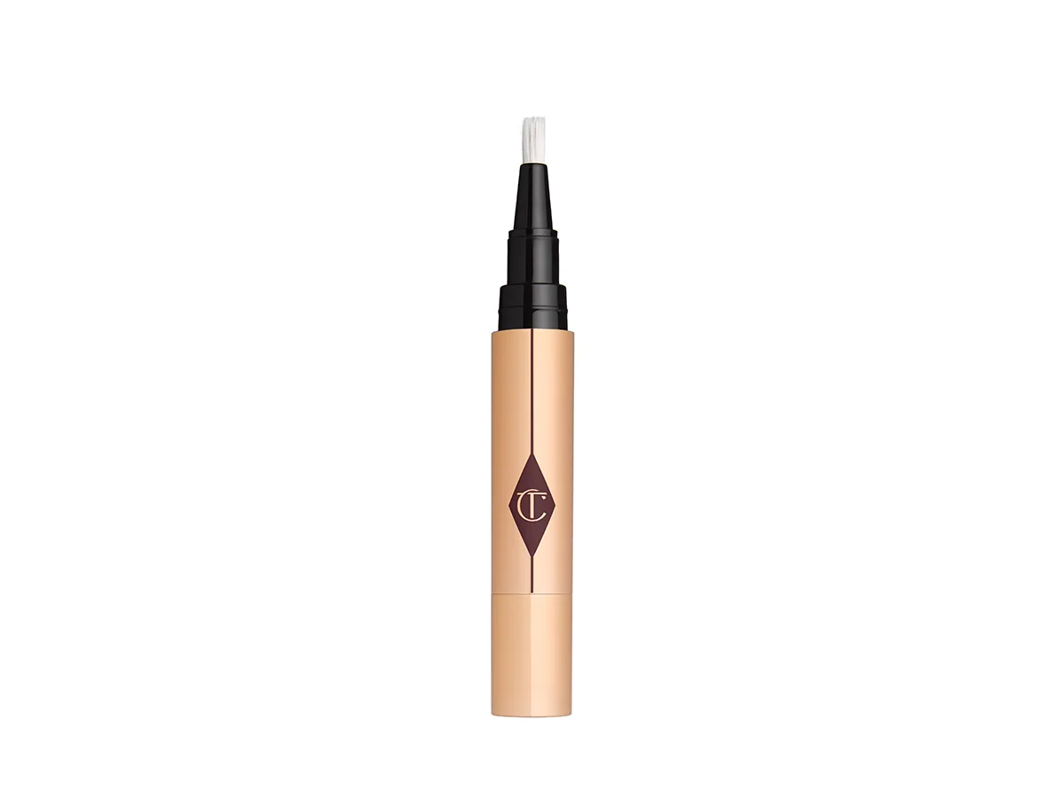An open creamy concealer in black and golden packaging. 
